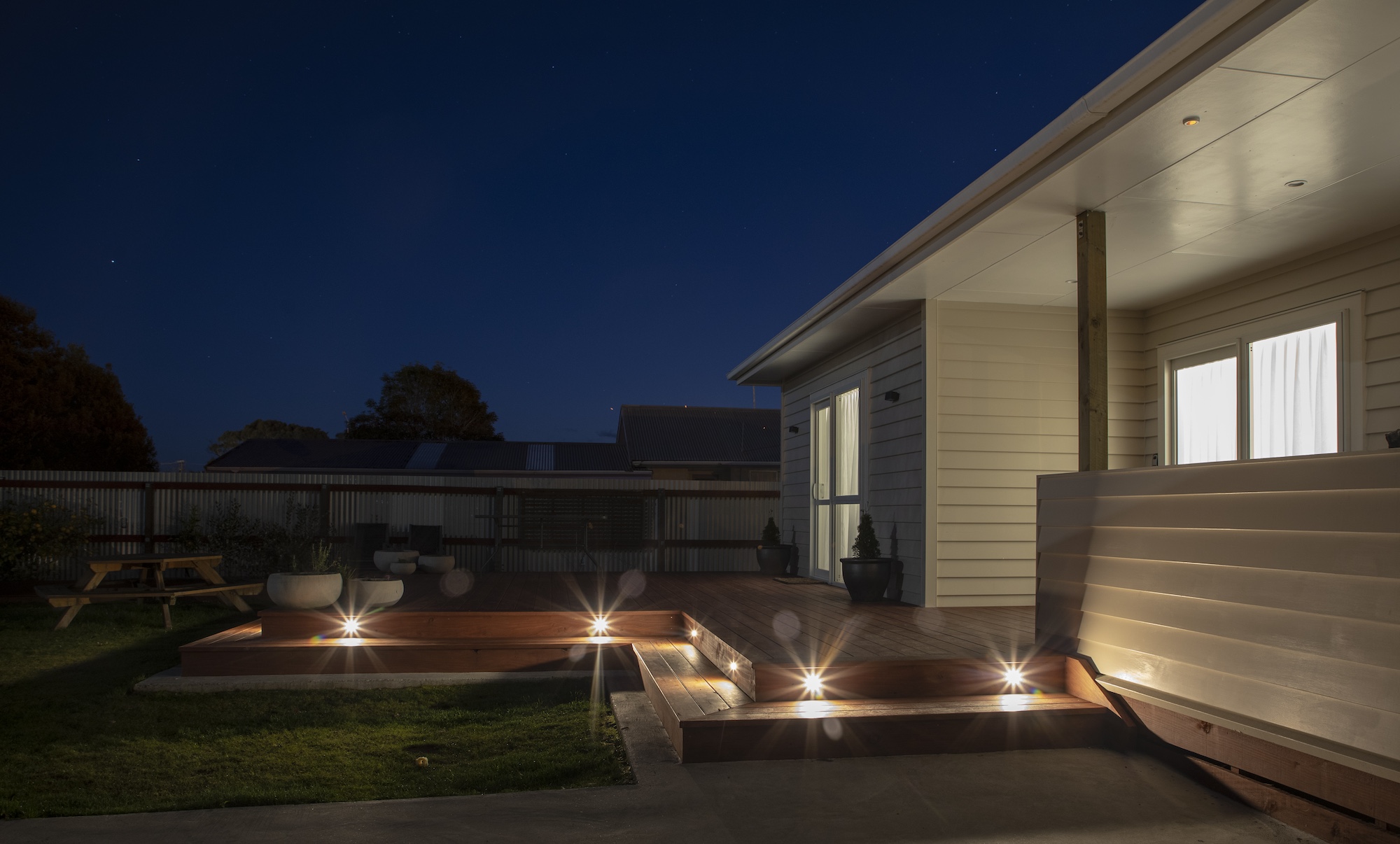 A house with a deck at night.