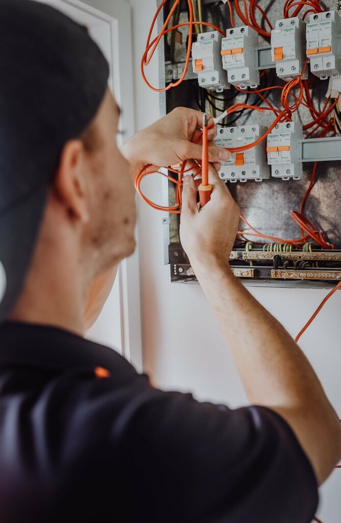 A man is working on an electrical panel.