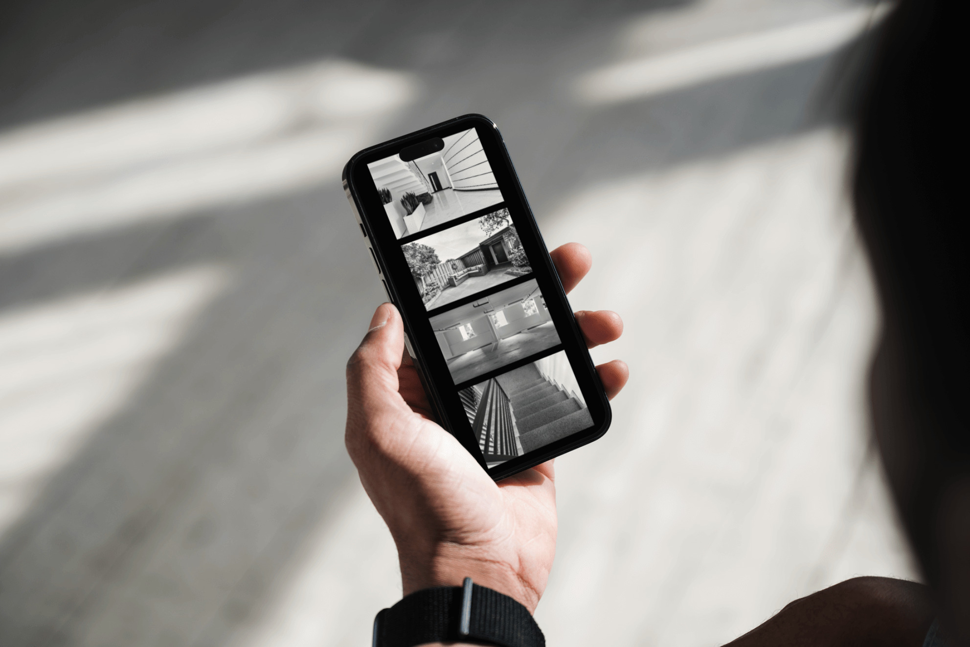 A person holding up a cell phone with several pictures on it.